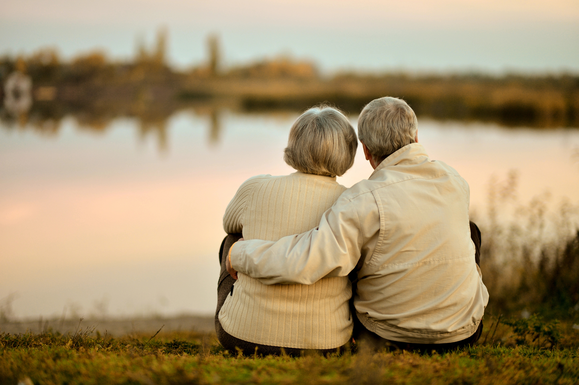 Elderly couple sit by the lake as they wonder Who Qualifies for Hospice?