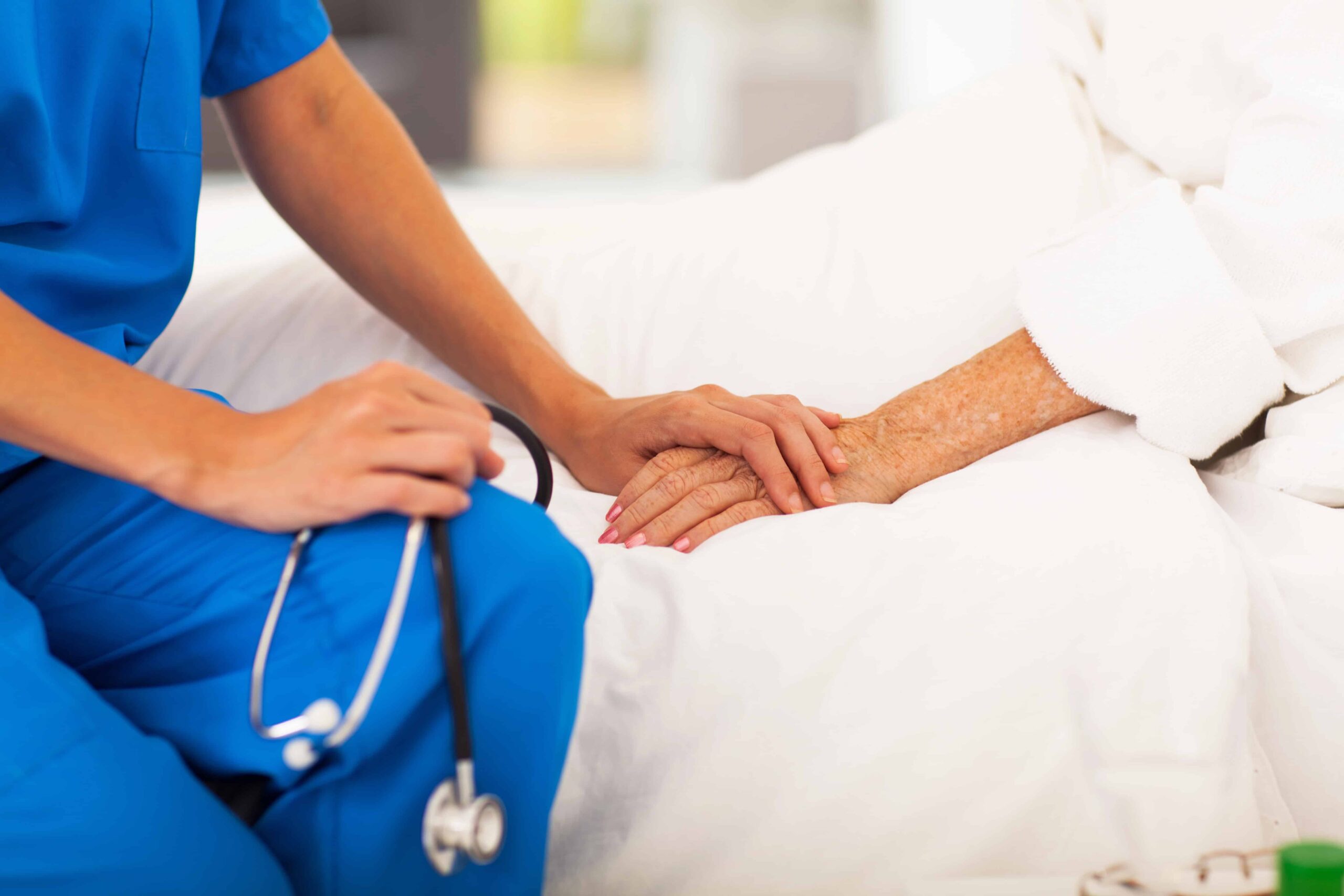 Medical professional holds the hand of a patient in Helena, MT Chronic Illness Palliative Care