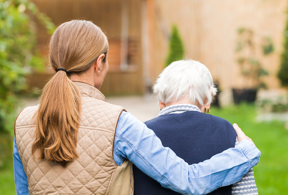 Helena, MT cancer patient palliative care provider has arm around patient as they take a walk outside