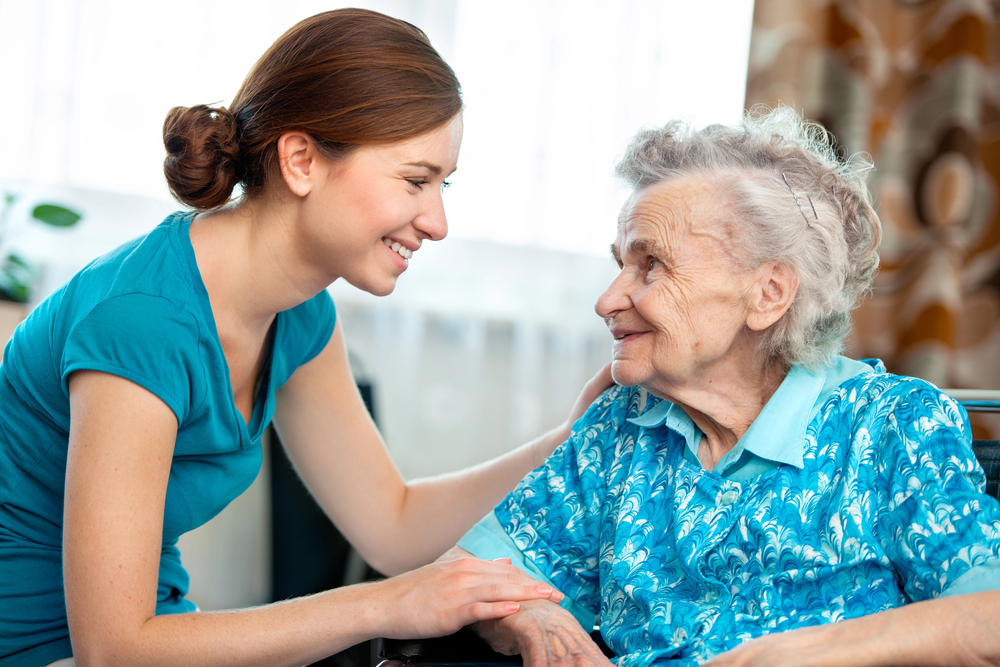 Granddaughter smiles at her grandmother as she wonders Who Pays For Hospice?