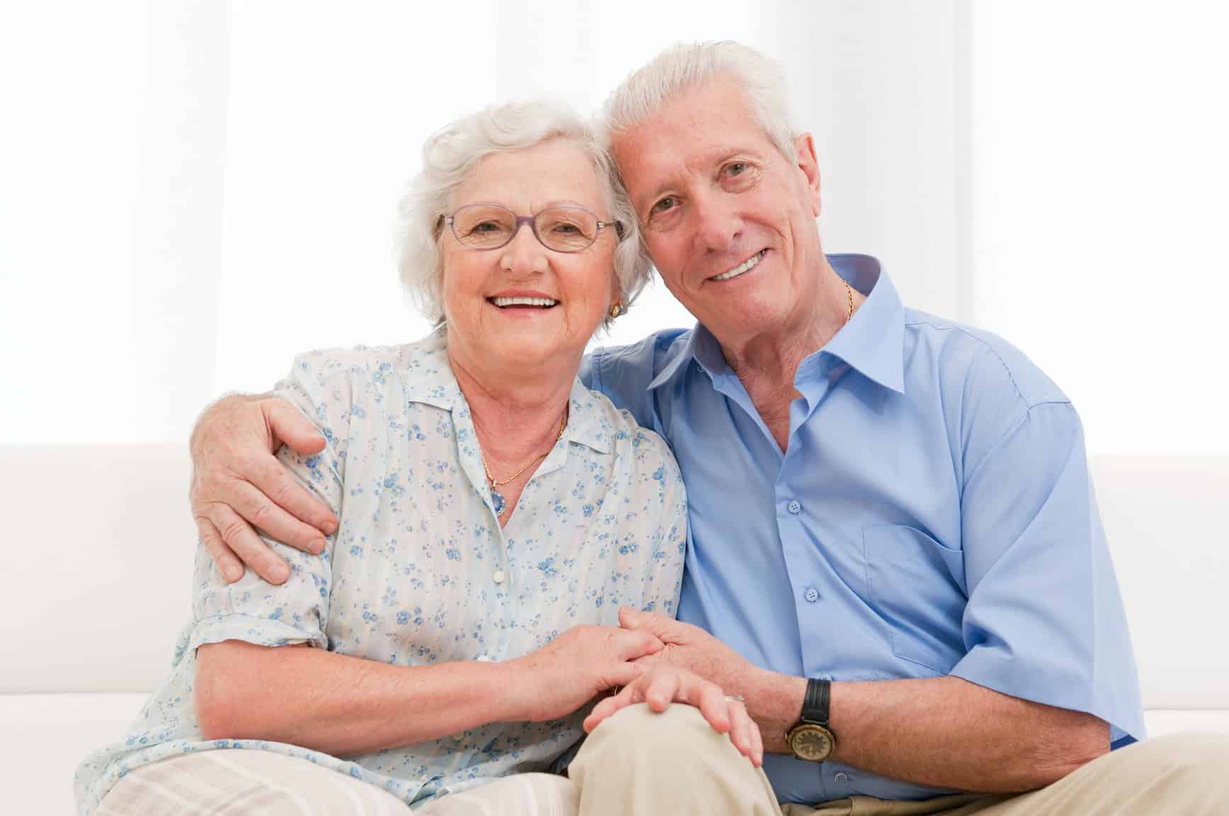 Eldlerly couple smiles as they ask who pays for palliative care